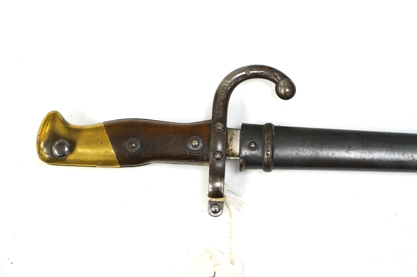 An 1875 French T-section bayonet in its steel scabbard for a Gras rifle, with engraving in French to the top of the blade. Condition - good